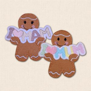 Two embroidered felt gingerbread characters holding 'I heart Mam' and 'I heart Mum' banners with pastel lettering and pink hearts.
