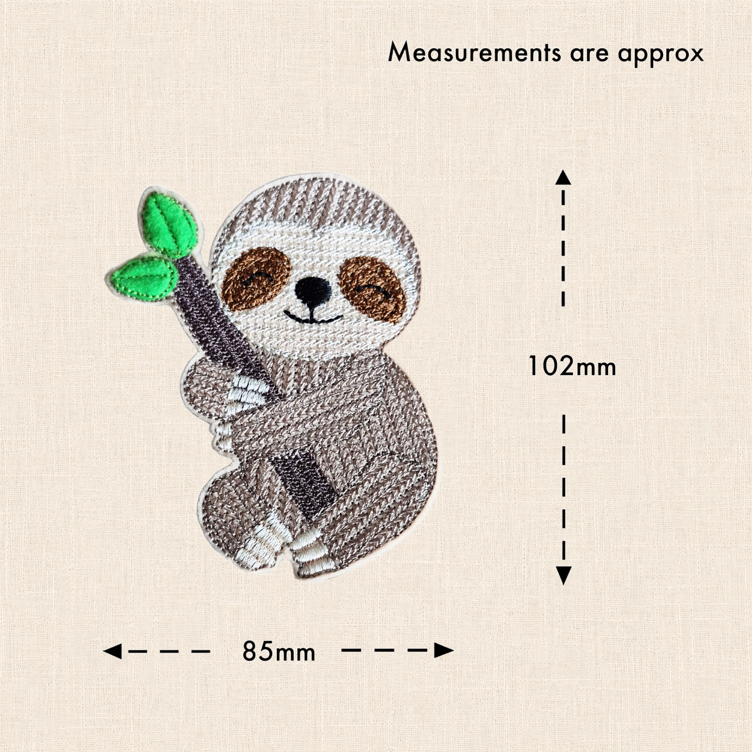 Felt sloth holding a leafy branch, with measurement arrows showing approximately 85mm wide and 102mm high, excluding the hanging loop.